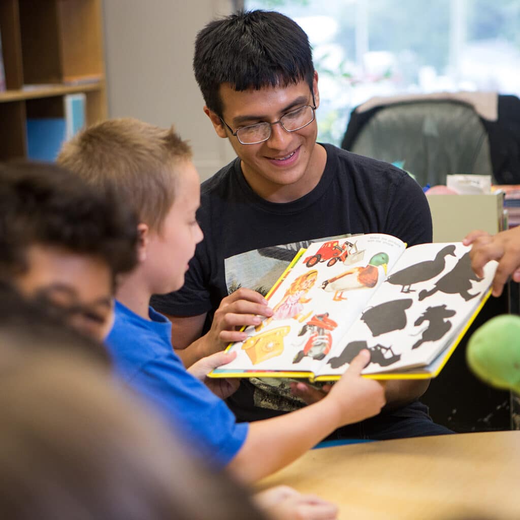 A man shows a young child a book