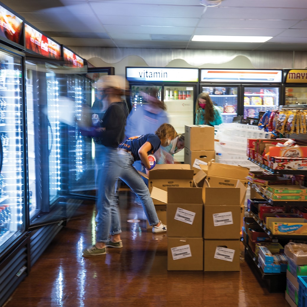 People loading freezers with food from boxes