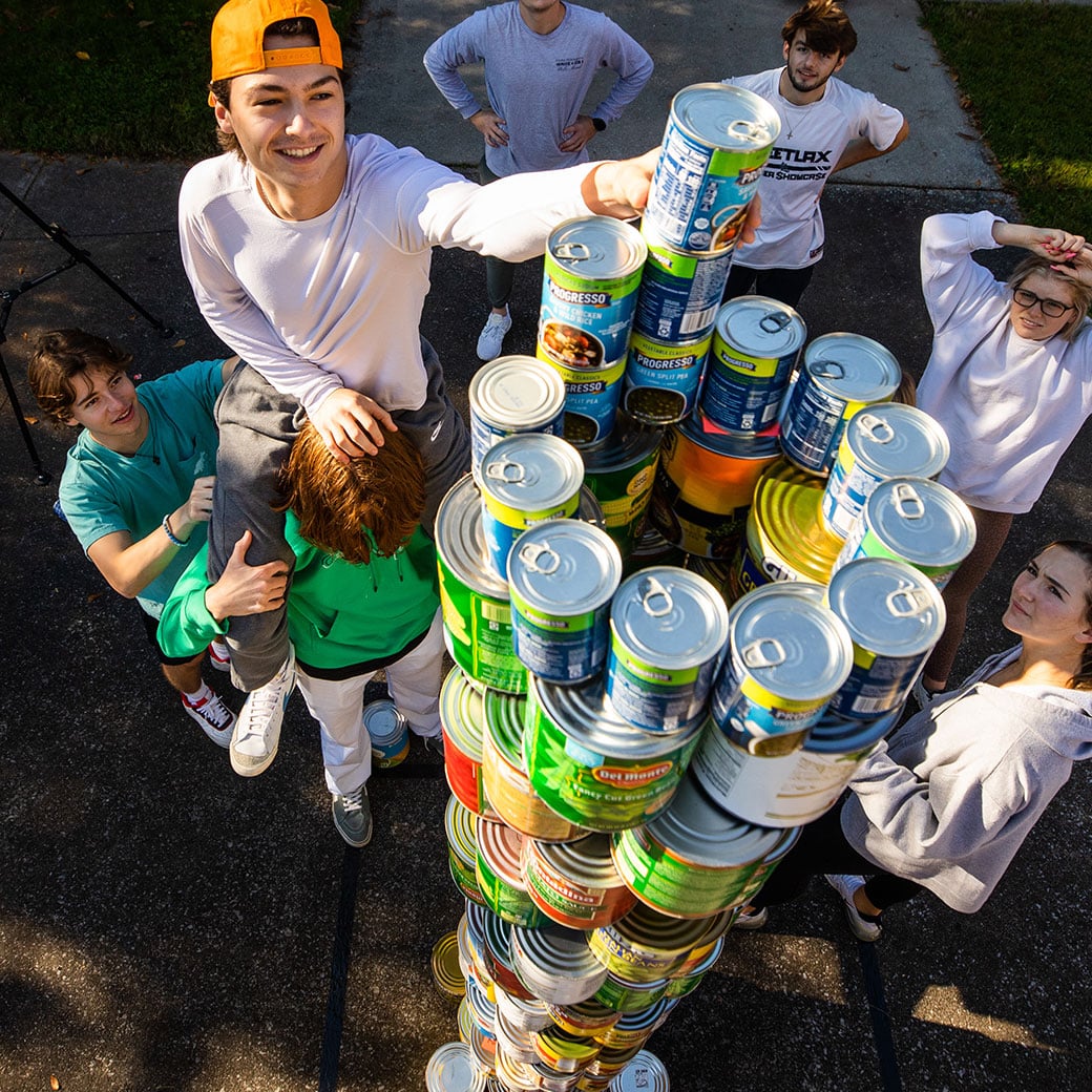 Students stack cans of food