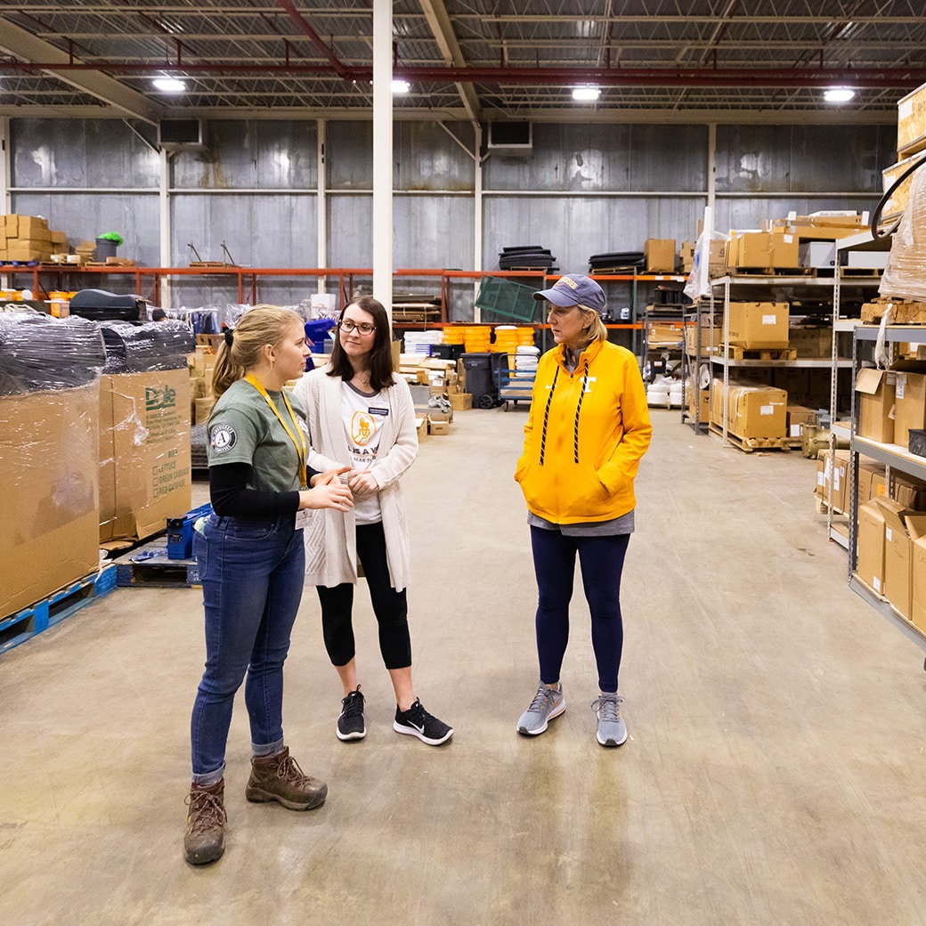 Three women standing in a warehouse