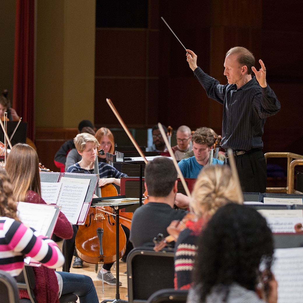 A conductor directing an orchestra