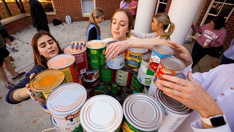 Students with a tower of food cans