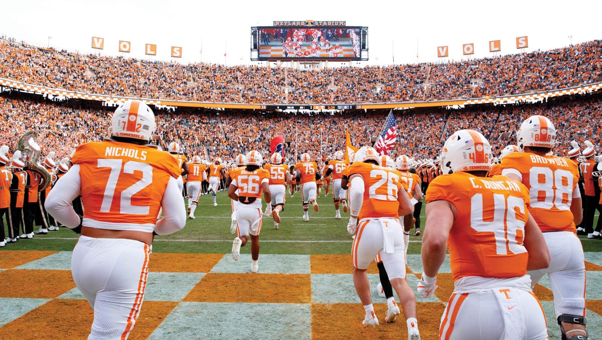 Football players running through the T as they enter Neyland Stadium