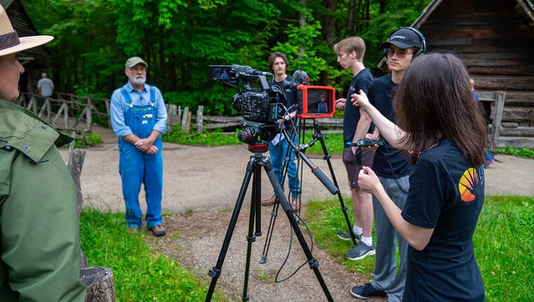 A man in overalls being interviewed on camera