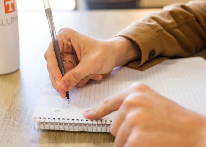 Close-up of a hand writing in a notebook