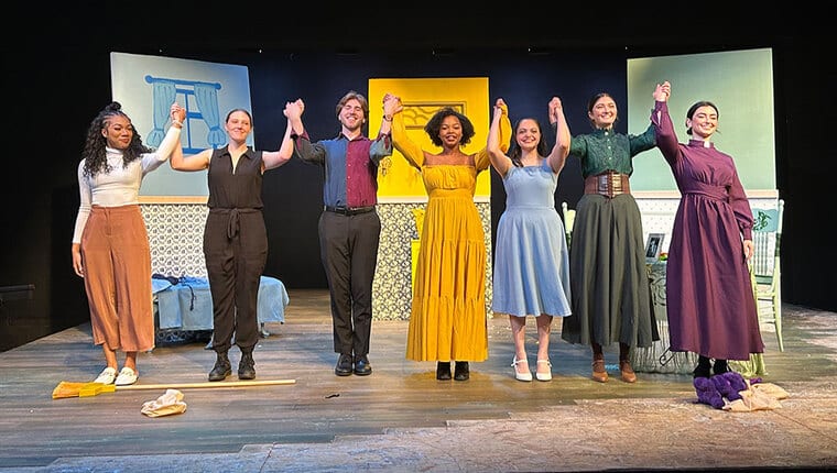 Seven students holding hands in preparation of taking a bow on stage.