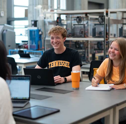 fye-2025-gallery-TCE-students Two smiling students sitting at a lab table.