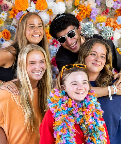 Students pose for a photo against a floral backdrop during Volapalooza.
