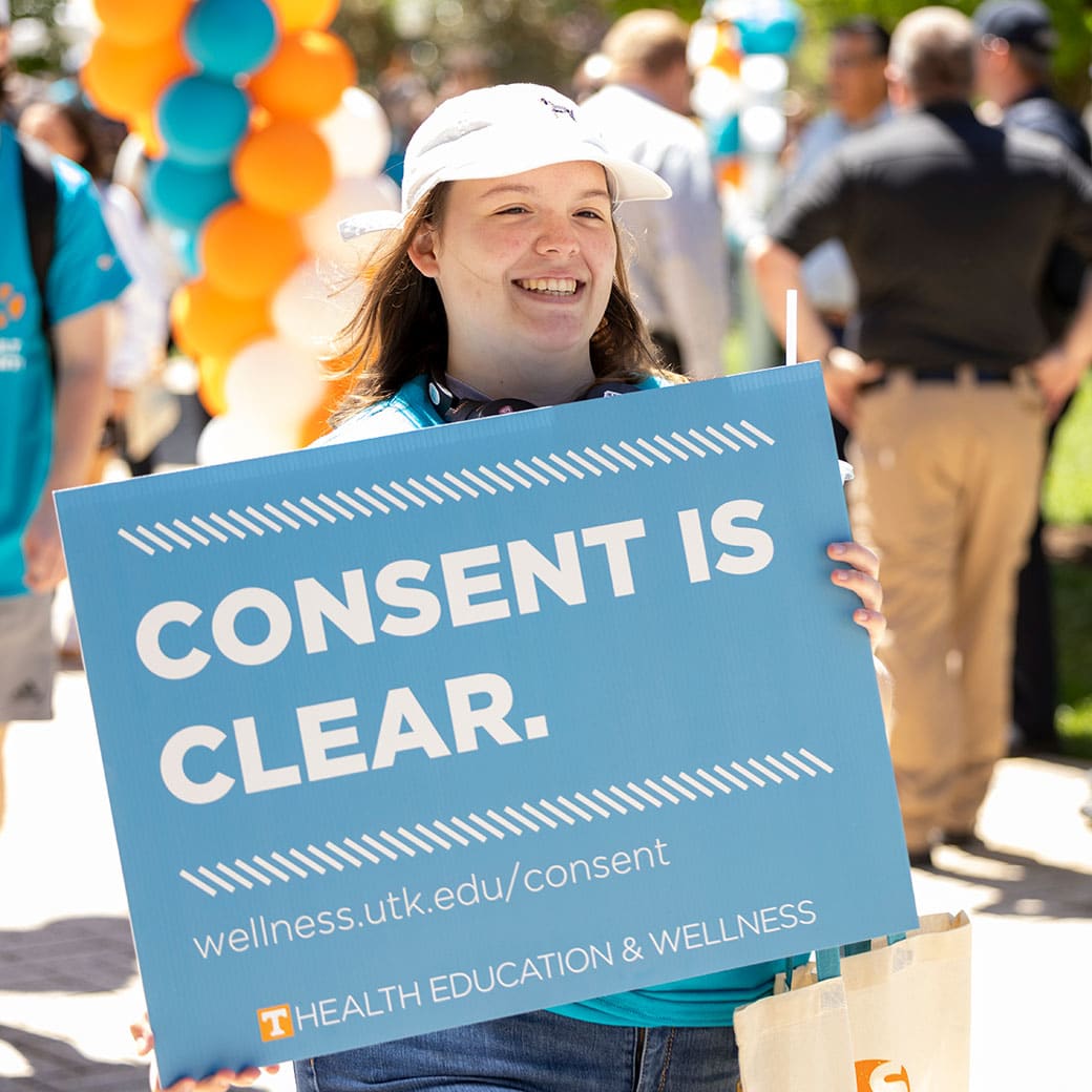 Person holding blue sign on UT campus
