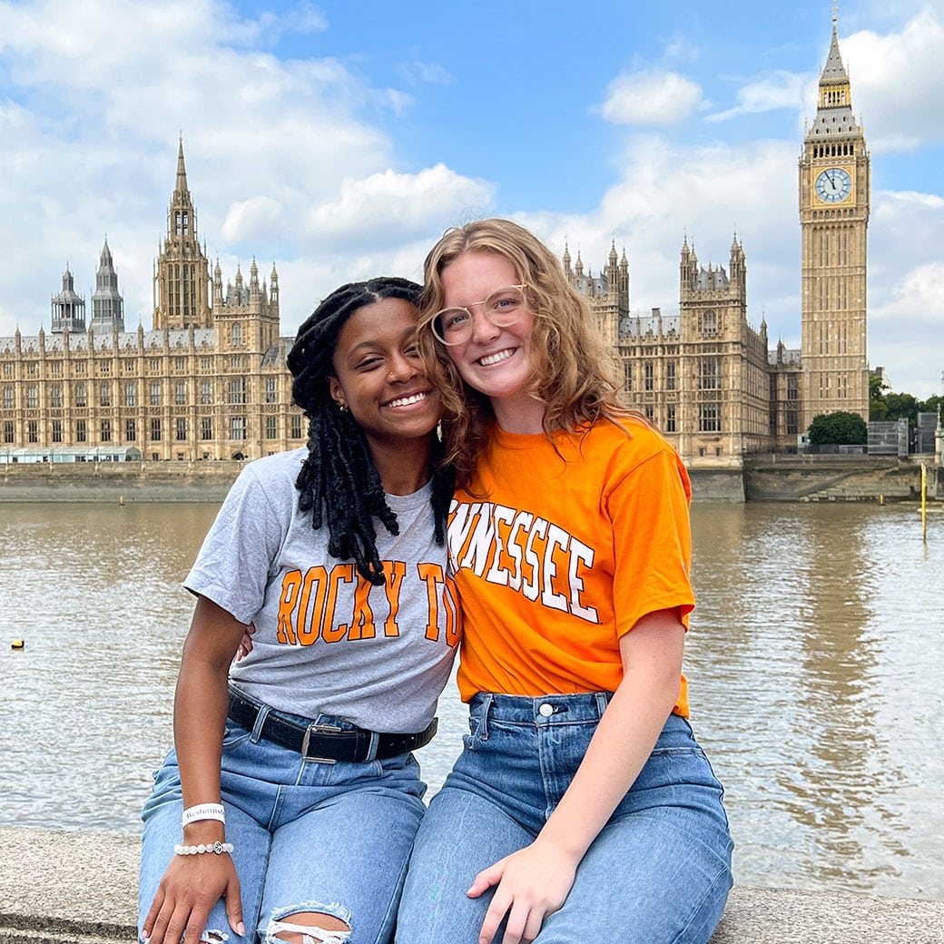 Ut student in vols shirts smiling in front of Big Ben clock in London 
