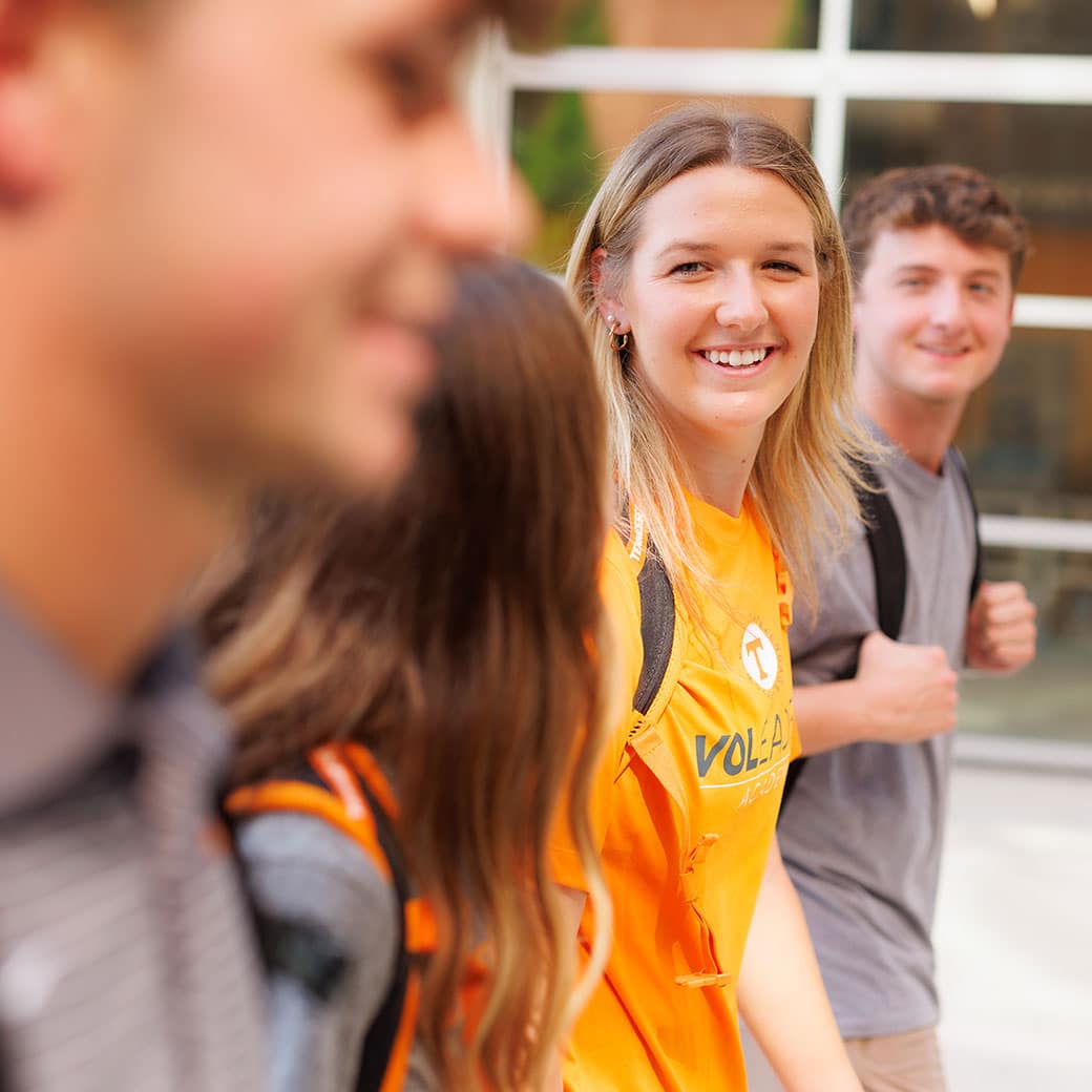 UT student walking and talking on campus