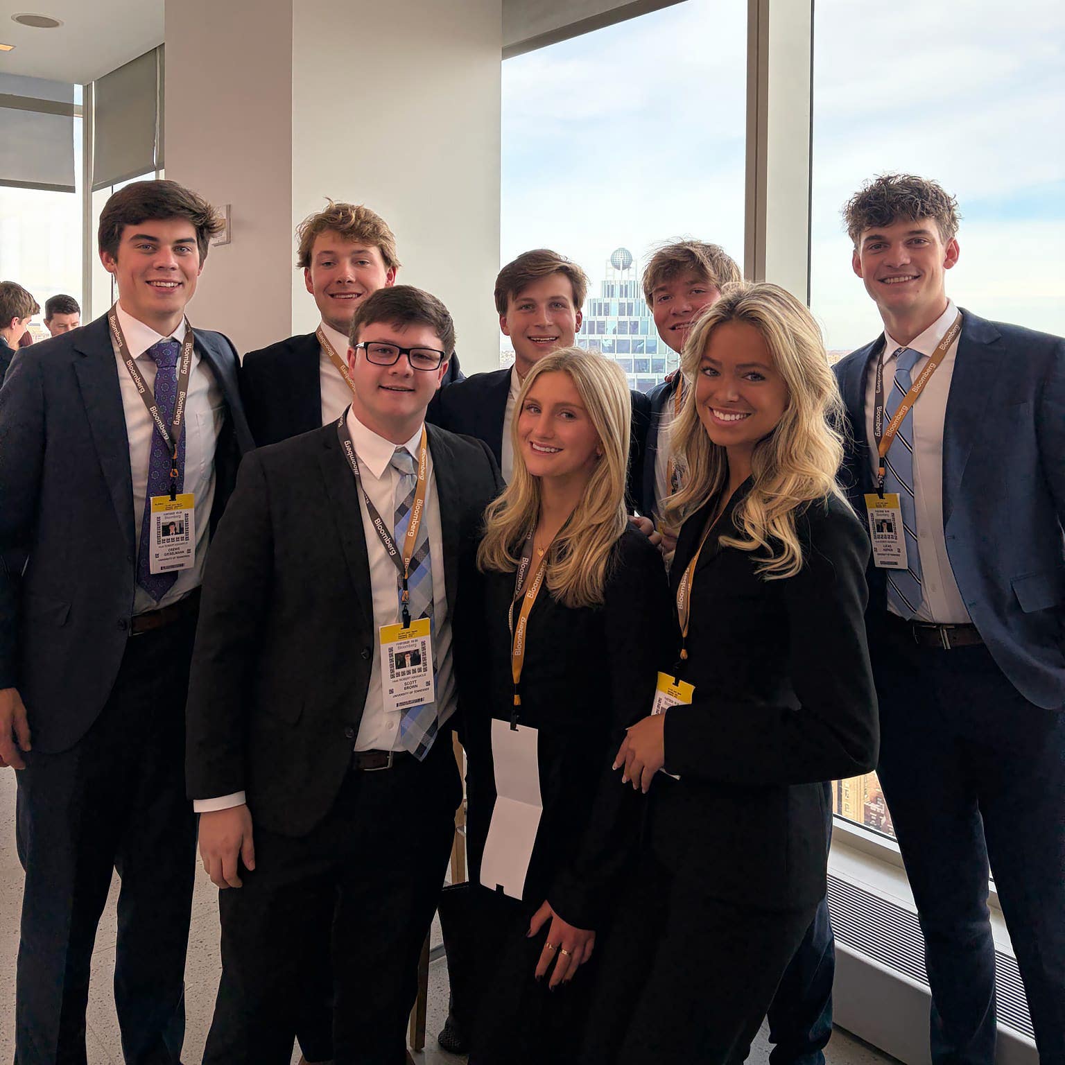Students in business clothes smiling in a group photo