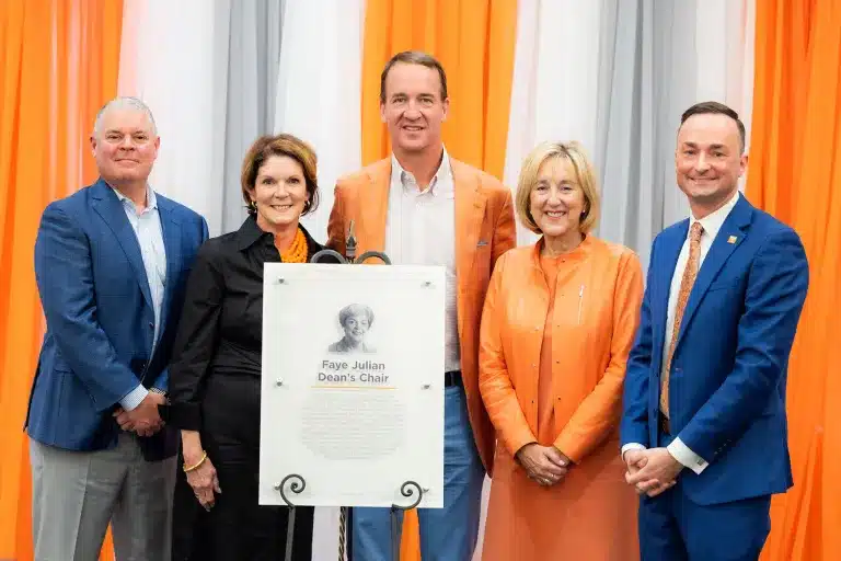 Peyton manning and others in a photo holding a plaque and smiling