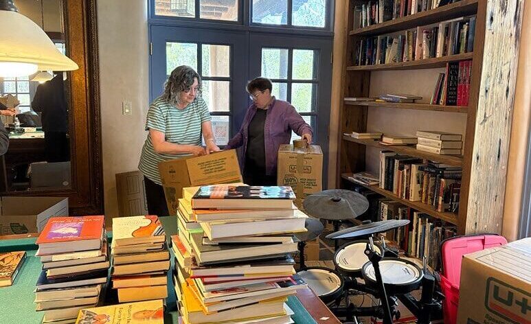 Two people in a library with books all around them