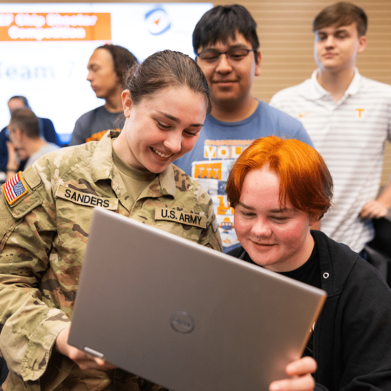 20230427_Engineering_Fundamentals_SB_027 Students in military uniforms looksing at computer screen smiling