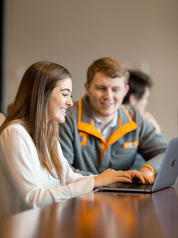 A female and a male student using a laptop