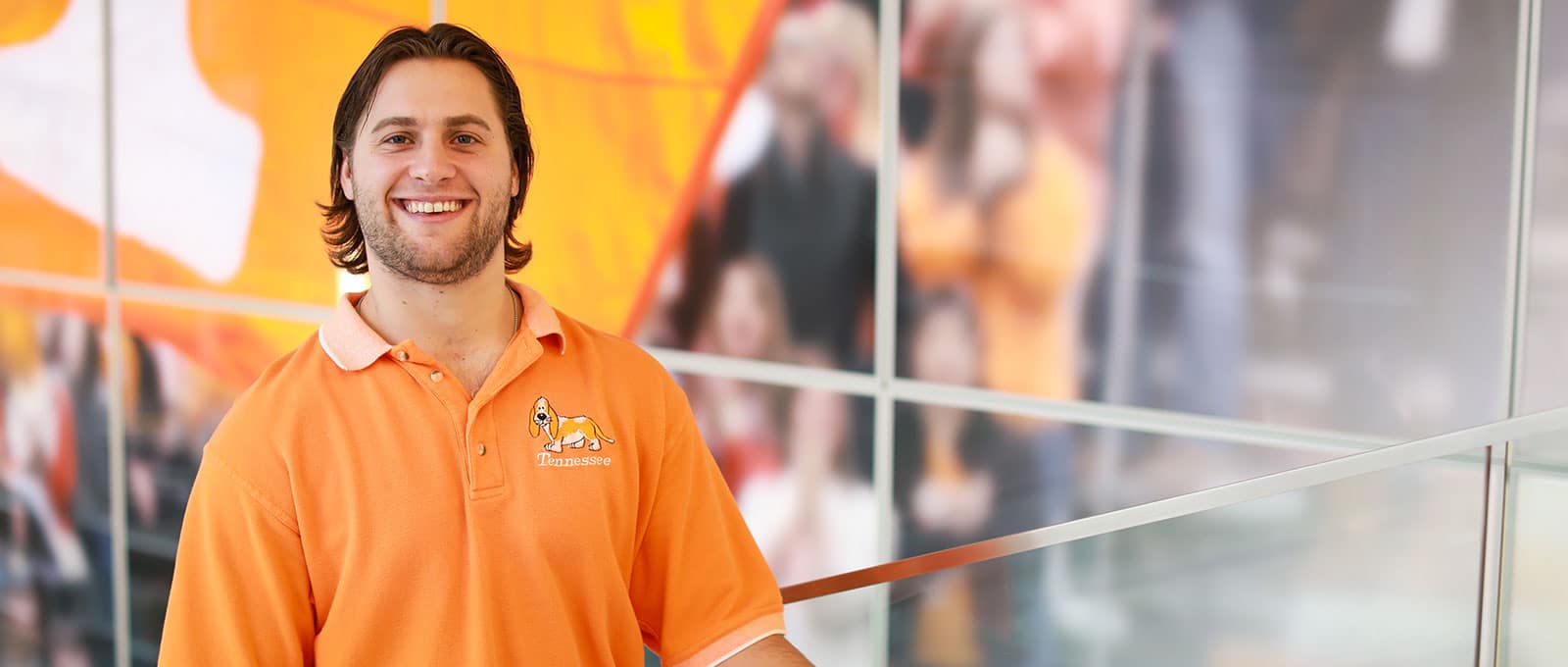 young man in orange polo shirt